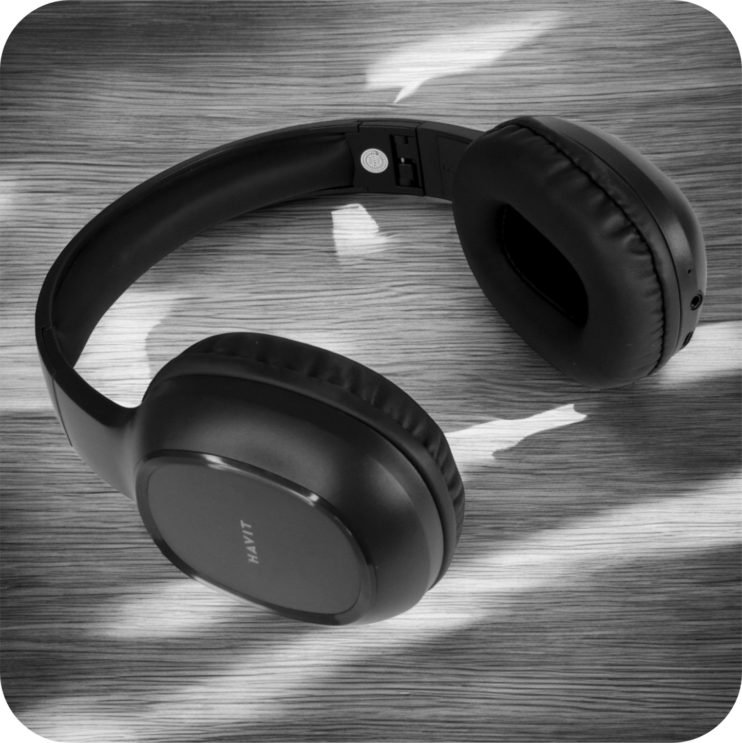 audifonos inalambricos negros de diadema sobre una superficie en blanco y negro 